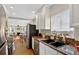 Beautiful kitchen featuring granite countertops, white cabinetry, stainless steel appliances and an open view to the living area at 2021 University Dr, Orlando, FL 32804