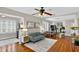 Inviting living room with hardwood floors, ceiling fan, and an open floor plan that seamlessly connects to the dining area at 2021 University Dr, Orlando, FL 32804