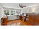 Bright office space featuring hardwood floors, multiple windows, and a ceiling fan at 2021 University Dr, Orlando, FL 32804