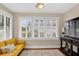 Cozy sitting area filled with natural light featuring a comfortable yellow couch and multiple windows with stylish blinds at 2021 University Dr, Orlando, FL 32804