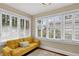 Bright sitting area with natural light featuring a cozy yellow couch and multiple windows with stylish blinds at 2021 University Dr, Orlando, FL 32804