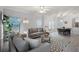 Spacious living room boasts large windows, plush seating, and a modern rug at 209 Villa Di Este Ter # 205, Lake Mary, FL 32746