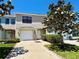 Charming townhome showcasing a well-manicured lawn and driveway, complemented by a flowering tree at 2120 Windsor Lake Cir, Sanford, FL 32773