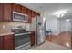 Well-equipped kitchen featuring stainless steel appliances, dark cabinets, and tiled flooring at 2120 Windsor Lake Cir, Sanford, FL 32773