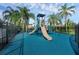 Community playground with a slide surrounded by palm trees and a secure fence at 2120 Windsor Lake Cir, Sanford, FL 32773