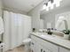 Bright bathroom features a granite countertop, updated light fixtures, and neutral-toned tile flooring at 2193 County Road 204, Oxford, FL 34484