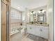 Luxurious bathroom featuring double sinks, garden tub, decorative tile, and updated lighting at 2193 County Road 204, Oxford, FL 34484