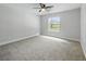 Spacious bedroom with neutral carpet, ceiling fan, and a large window providing plenty of natural light at 2193 County Road 204, Oxford, FL 34484