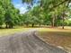 Scenic driveway winding through a lush, tree-lined landscape, creating a tranquil entrance to the property at 2193 County Road 204, Oxford, FL 34484