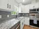 Modern kitchen with stainless steel appliances, granite countertops, and stylish backsplash at 2193 County Road 204, Oxford, FL 34484
