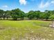 Large grassy yard surrounded by mature trees under a blue sky at 2193 County Road 204, Oxford, FL 34484