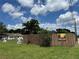 View of a street with a wooden fence and a glimpse of nearby residences under a sunny sky at 2223 Kilmer Ln, Apopka, FL 32703