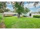Sprawling backyard with lush green grass, mature shade tree and brick home at 2500 Lake Shore Dr, Orlando, FL 32803