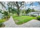 Expansive backyard featuring lush green grass, mature trees, and stone pavers at 2500 Lake Shore Dr, Orlando, FL 32803