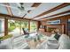Comfortable living room with a brick fireplace, beamed ceilings, and a patio view at 2500 Lake Shore Dr, Orlando, FL 32803