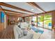 Open living area with beamed ceilings, a tile floor, and comfortable seating, leading to the patio at 2500 Lake Shore Dr, Orlando, FL 32803