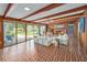 Bright living room boasts wood-paneled walls, exposed ceiling beams, and access to a patio at 2500 Lake Shore Dr, Orlando, FL 32803