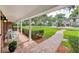 Covered front porch with brick flooring, white columns, seating, and a walkway to the street at 2500 Lake Shore Dr, Orlando, FL 32803