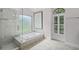 Bright bathroom with a separate shower and bathtub with natural light from two windows at 2608 Westminster Ter, Oviedo, FL 32765