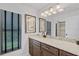 Bathroom featuring a vanity with a granite countertop, undermount sink, decorative lighting and large mirror at 2608 Westminster Ter, Oviedo, FL 32765