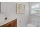 Half bathroom featuring a toilet, artwork, granite countertop and shuttered window at 2608 Westminster Ter, Oviedo, FL 32765