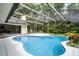 Swimming pool with clear blue water, a screen enclosure, and lush tropical landscaping at 2608 Westminster Ter, Oviedo, FL 32765