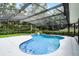 Sparkling blue pool surrounded by a screened enclosure and lush landscaping at 2608 Westminster Ter, Oviedo, FL 32765