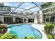 Screened-in pool featuring an outdoor kitchen, covered lounge areas, and lush landscaping at 2608 Westminster Ter, Oviedo, FL 32765