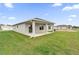 Spacious backyard featuring a covered patio, lush green grass, and a view of neighboring houses at 2644 Hancock Crossing Dr, Bartow, FL 33830