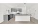 Modern kitchen with gray cabinets, an island with granite countertops, stainless steel appliances, and tile flooring at 2644 Hancock Crossing Dr, Bartow, FL 33830