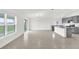 Open concept living room featuring tile flooring, abundant natural light, and a view of the modern kitchen at 2644 Hancock Crossing Dr, Bartow, FL 33830
