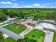 Aerial view of a single-Gathering home, highlighting its long driveway, well-manicured lawn, and serene backyard view at 27714 Lois Dr, Tavares, FL 32778