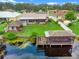 Aerial view of the home and property showcasing the boat dock, summer kitchen, and lake views at 27714 Lois Dr, Tavares, FL 32778