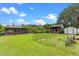 A large grass yard featuring a boat house, a summer kitchen, a shed, and a fenced in garden at 27714 Lois Dr, Tavares, FL 32778