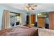 Bright bedroom featuring a ceiling fan, dresser with television, and sliding glass doors to the outside at 27714 Lois Dr, Tavares, FL 32778