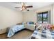 Cozy bedroom featuring twin beds, a ceiling fan, and natural light at 27714 Lois Dr, Tavares, FL 32778