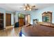 This spacious bedroom features a ceiling fan, wood floors, and dresser with mounted television at 27714 Lois Dr, Tavares, FL 32778