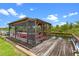 Covered boat dock features a wooden deck and a red boat providing secure mooring and waterfront enjoyment at 27714 Lois Dr, Tavares, FL 32778