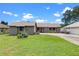 Inviting single-story home with a well-manicured lawn and quaint landscaping, perfect for suburban living under a bright blue sky at 27714 Lois Dr, Tavares, FL 32778