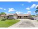 Charming single-story home boasts a long driveway, attached garage, and mature landscaping for inviting curb appeal at 27714 Lois Dr, Tavares, FL 32778