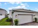Attached two-car garage featuring brick pavers and a view of manicured landscaping at 3124 Addison Blvd, St Cloud, FL 34771