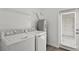 Functional laundry room with white washer and dryer units, a water heater, and a wire rack shelf at 3124 Addison Blvd, St Cloud, FL 34771