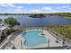 Aerial view of a luxurious community pool surrounded by lush greenery and lake at 3124 Addison Blvd, St Cloud, FL 34771