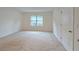 A spacious carpeted bedroom with a window and doorway at 3202 Timber Hawk Cir, Ocoee, FL 34761