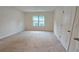 Well-lit bedroom with carpet flooring and a large window overlooking the landscape at 3202 Timber Hawk Cir, Ocoee, FL 34761