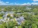 Aerial view of the neighborhood, featuring lush green trees and well-maintained houses, near a city skyline at 3226 Helen Ave, Orlando, FL 32804