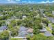 A high aerial perspective showcases a residential area with lush trees and well-maintained homes with blue skies at 3226 Helen Ave, Orlando, FL 32804