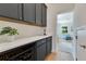 Butler pantry features gray cabinets, wine storage, quartz countertop, and provides passage to another room at 3226 Helen Ave, Orlando, FL 32804