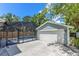 View of the two-car garage and the screened-in pool with a blue house and a spacious concrete driveway at 3226 Helen Ave, Orlando, FL 32804