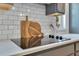 Close-up of the stovetop with white subway tile backsplash, featuring butcher block cutting boards and utensil holder at 3226 Helen Ave, Orlando, FL 32804